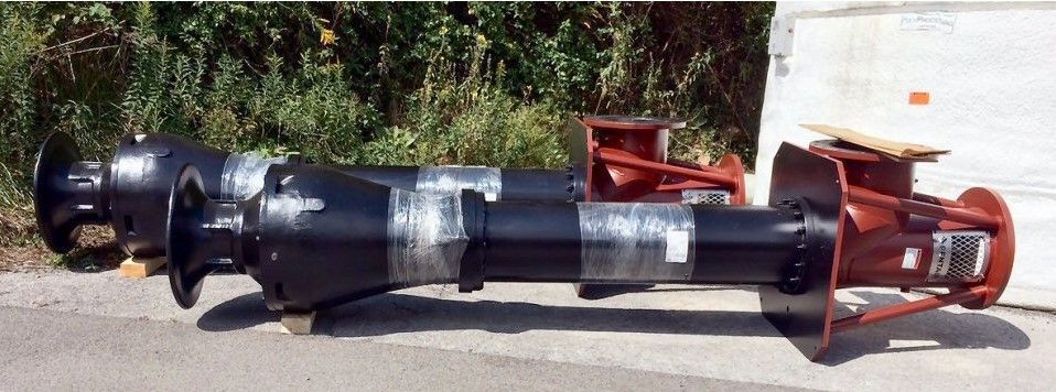A large black pipe is sitting on the side of the road.