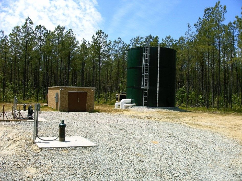 A large green tank with a ladder on top of it