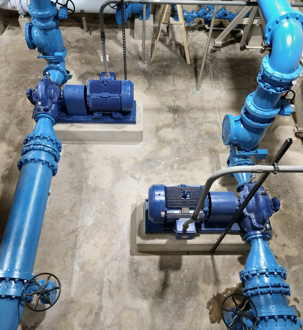 A room with a lot of blue pipes and pumps