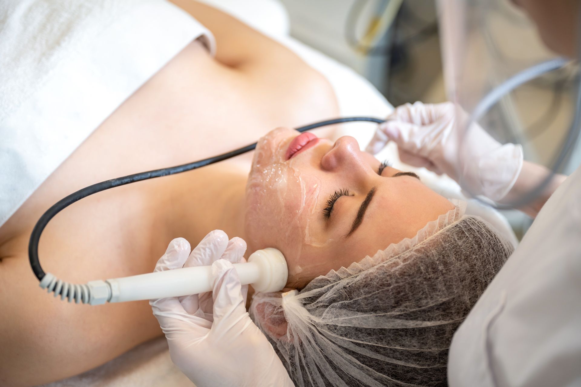 A woman is getting a facial treatment at a beauty salon.
