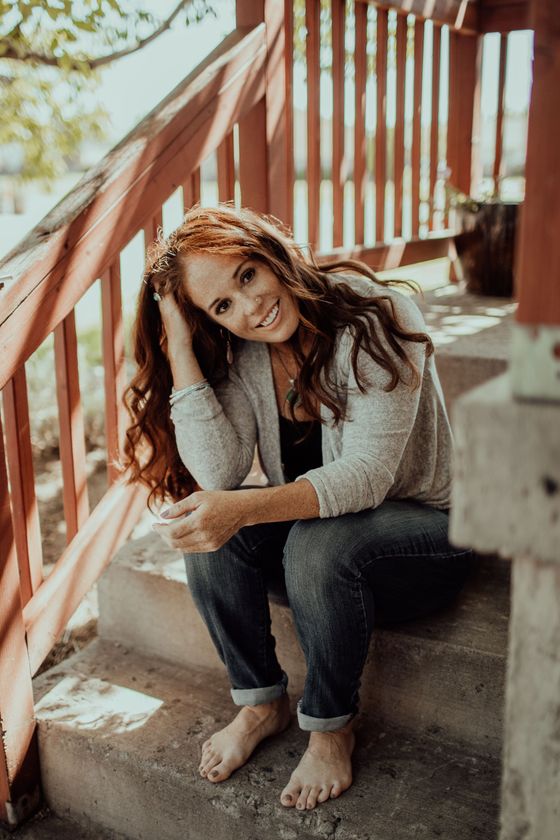 A woman is sitting on the steps of a house.