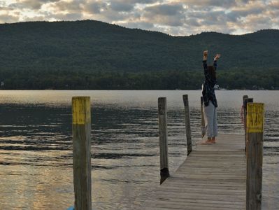 A person standing on a dock with their arms in the air