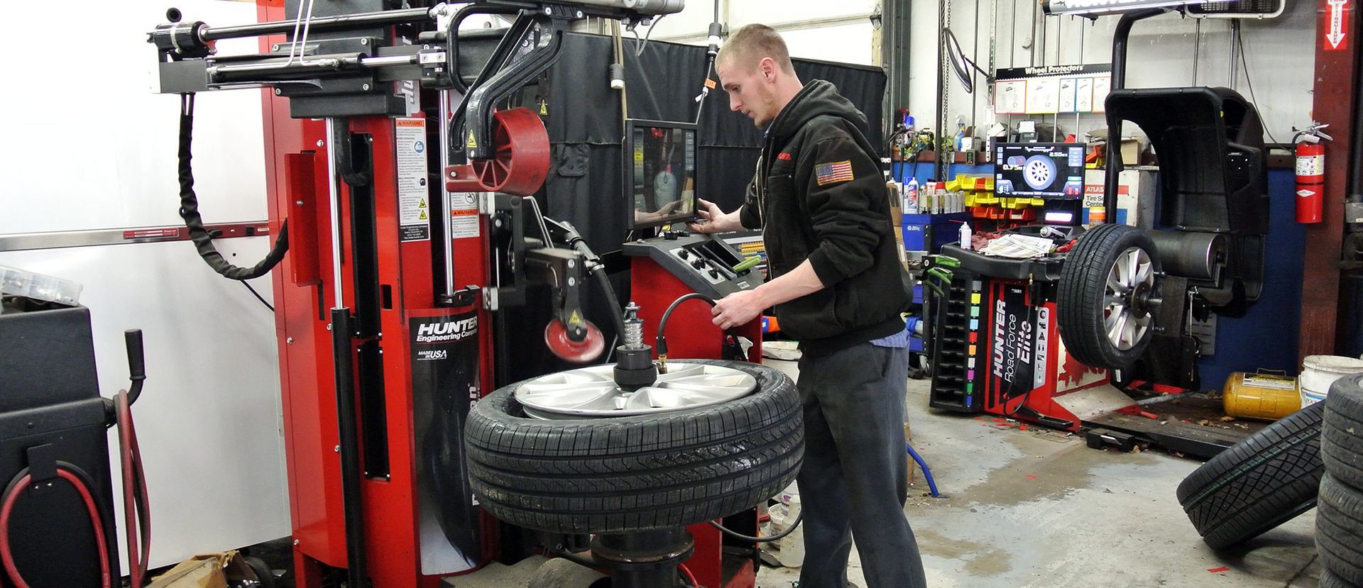 Technician Mounting And Balancing Tire Using Professional Equipment | Neubauer's Auto Repair