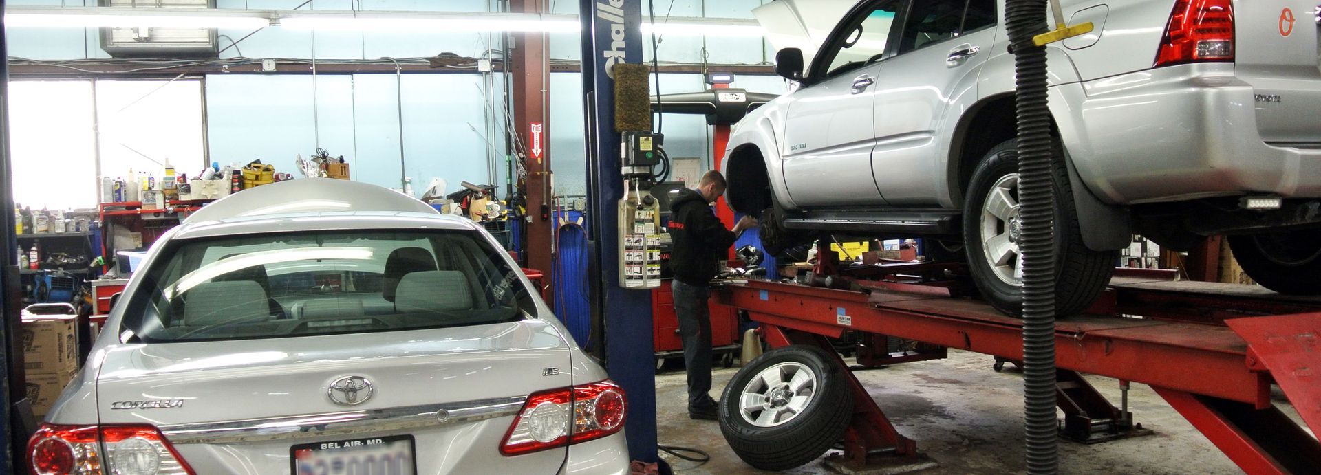 Vehicle Maintenance Service On Hydraulic Lift Inside Repair Shop | Neubauer's Auto Repair