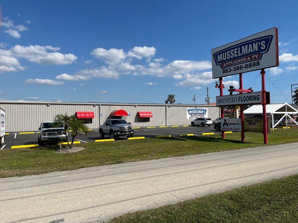 A white building with a red awning and a sign that says ' wiselman 's ' on it.