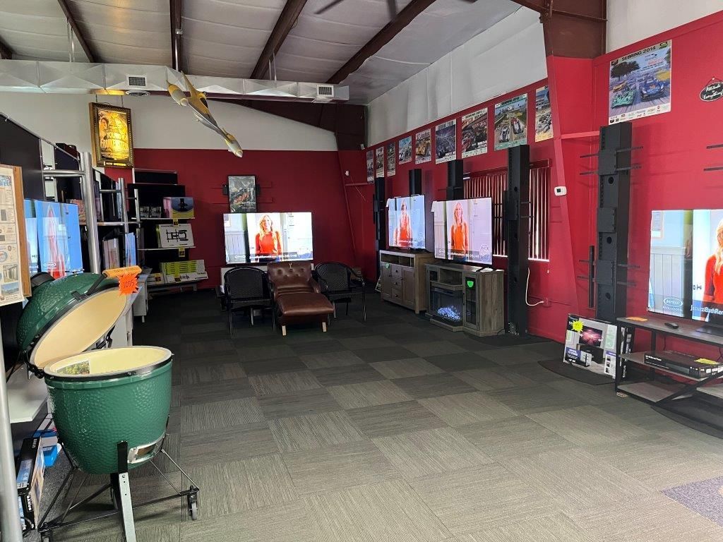 A large room filled with lots of televisions and a green egg.