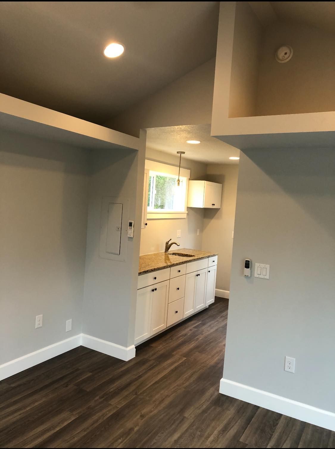 A kitchen with a sink and cabinets in an empty room.