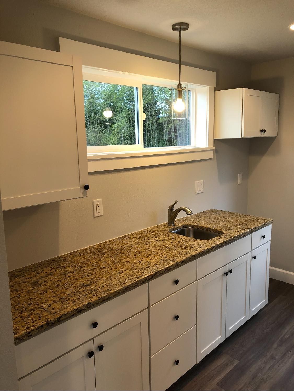A kitchen with granite counter tops and white cabinets