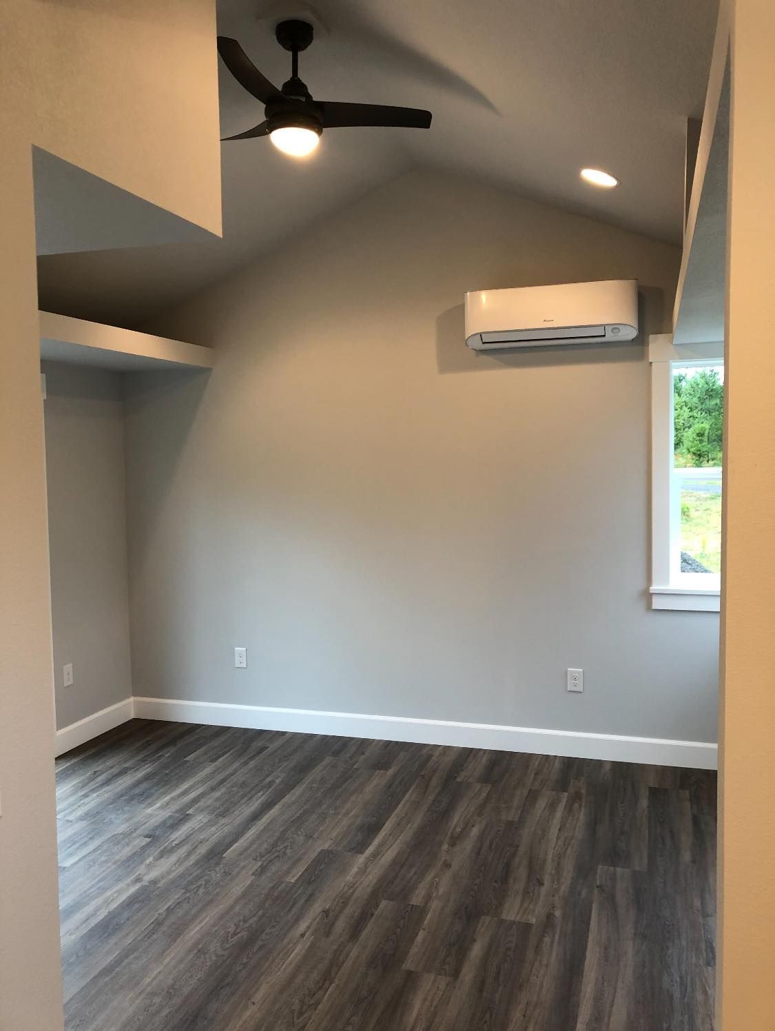 An empty room with a ceiling fan and a window