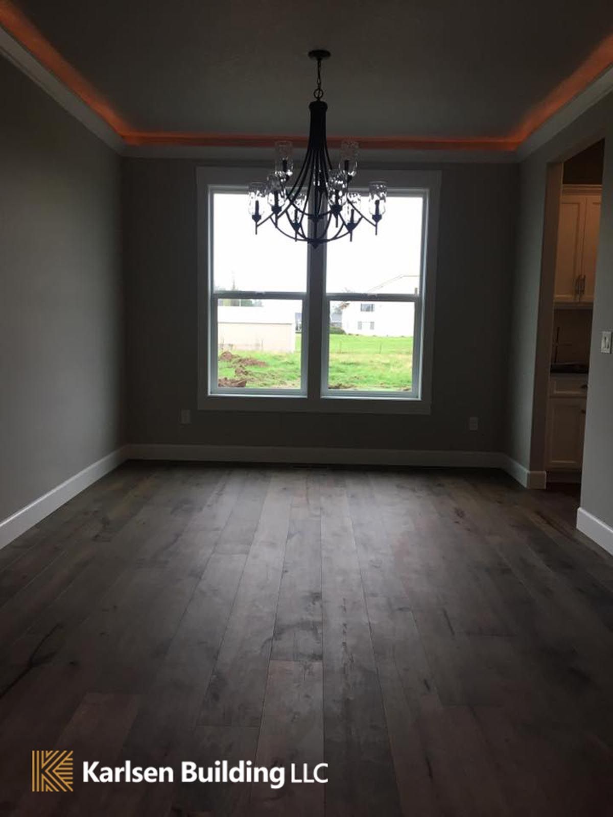 An empty room with a chandelier and a sign that says karlsen building llc