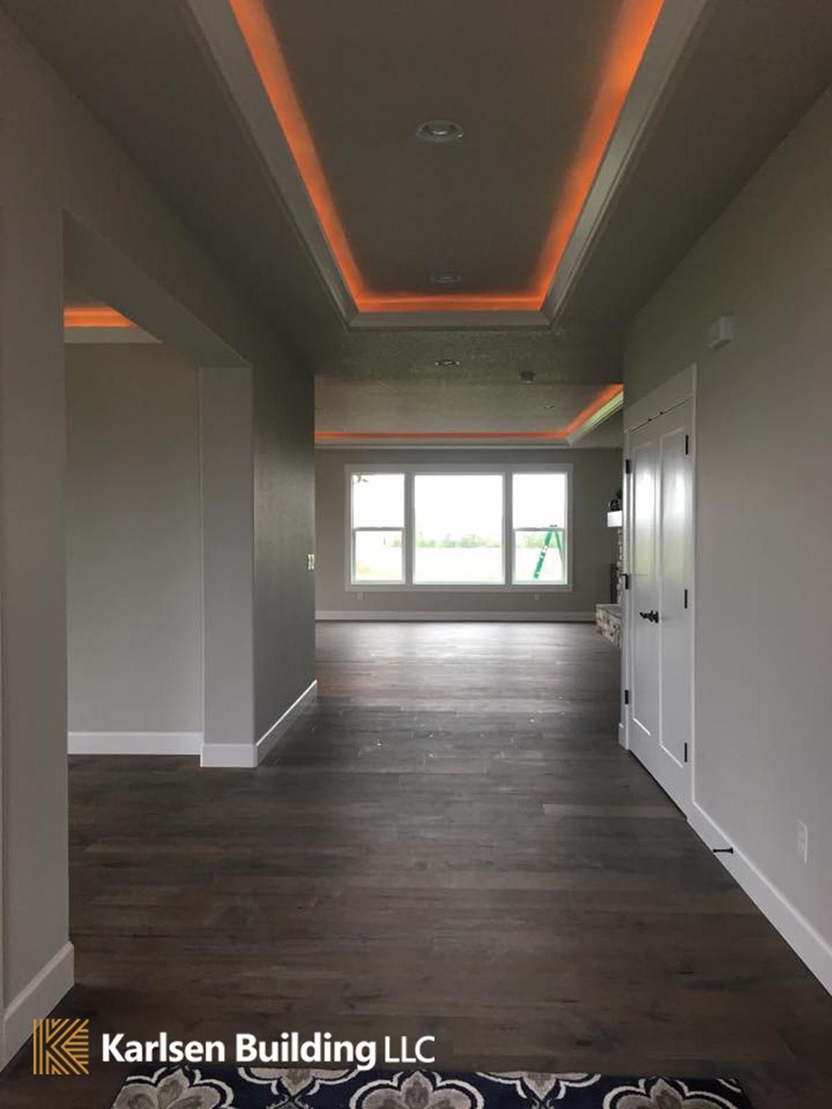 A hallway with hardwood floors and a ceiling light.