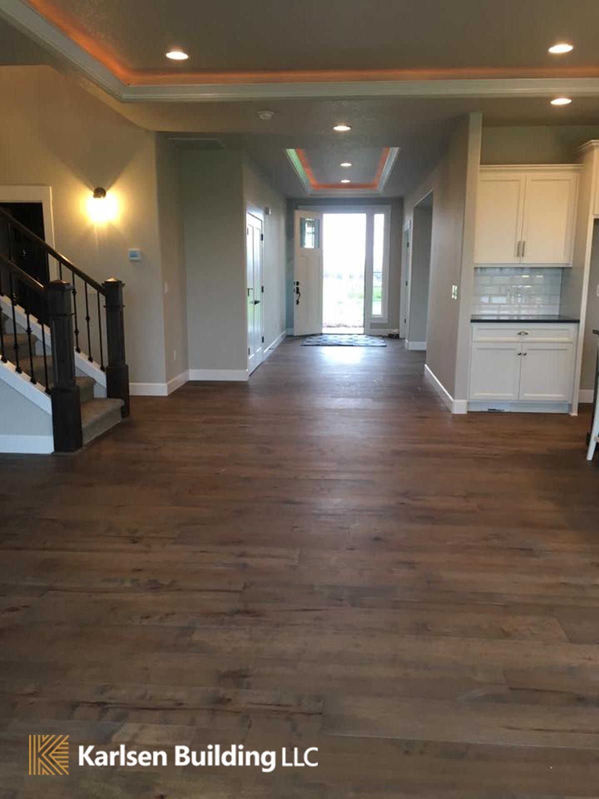A large empty room with hardwood floors and stairs.