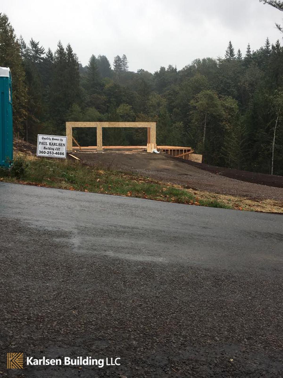 A sign for karlsen building llc is on the side of the road