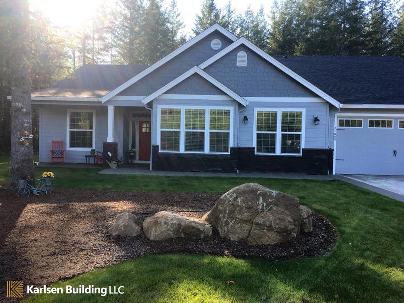 A large house with a large rock in front of it