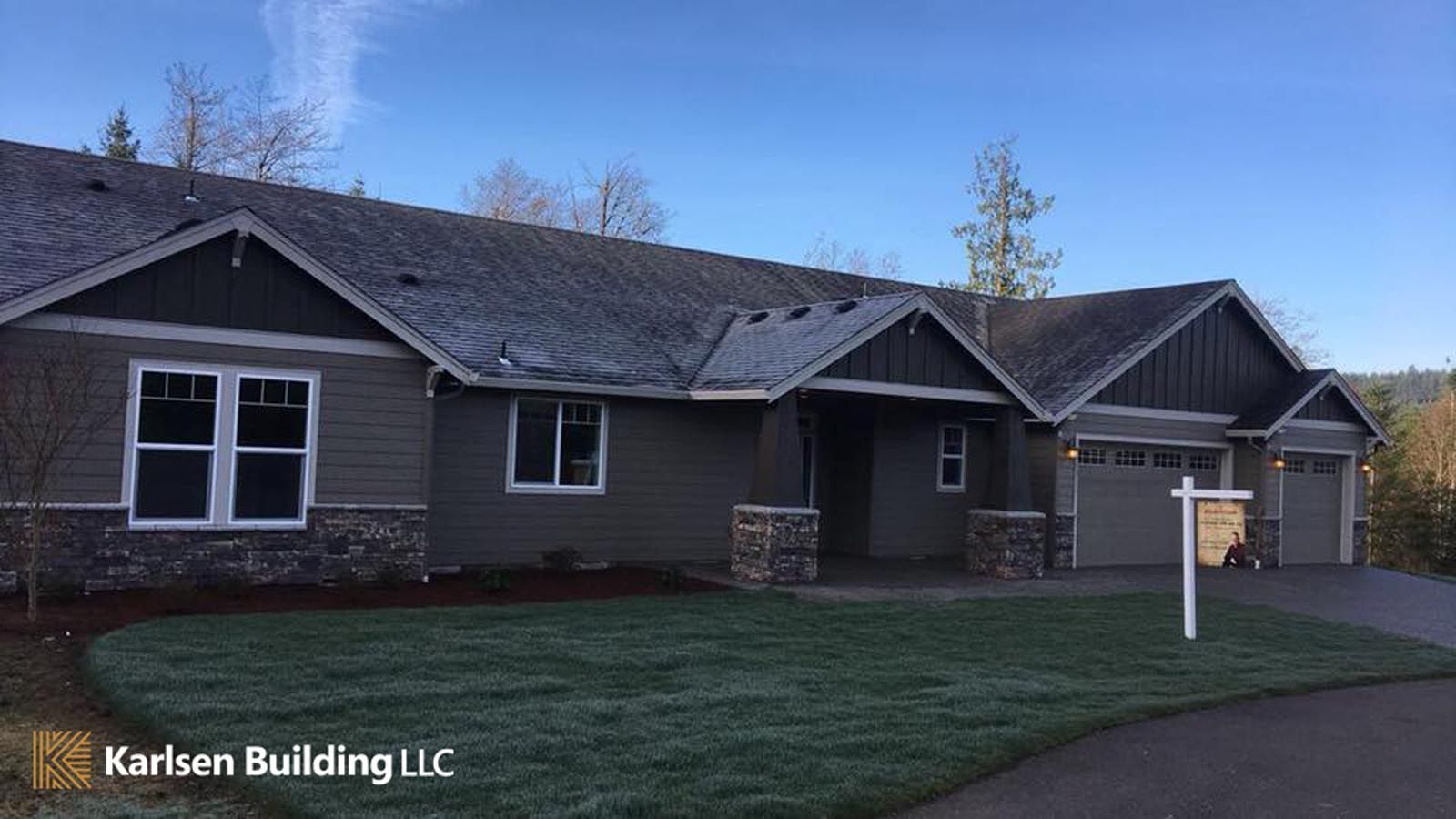 A large house with a for sale sign in front of it.