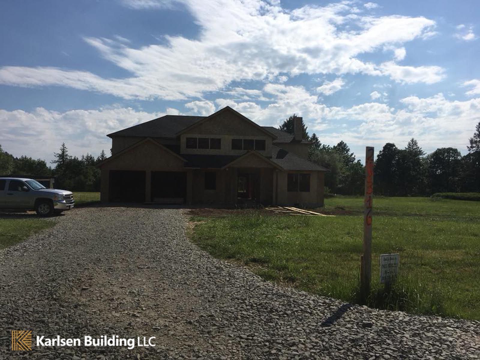 A car is parked in front of a house under construction
