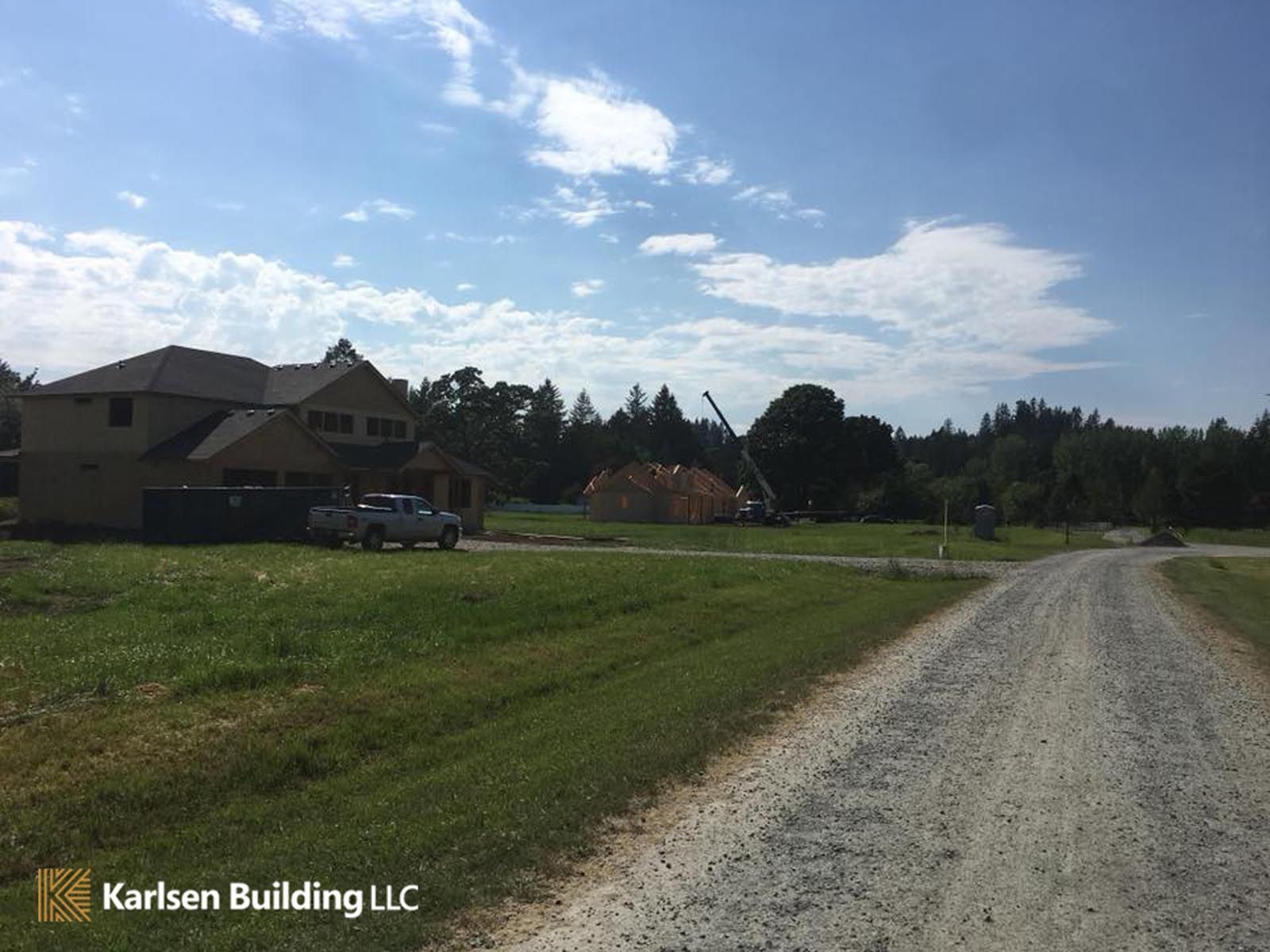 A dirt road leading to a house that is being built by karlsen building llc