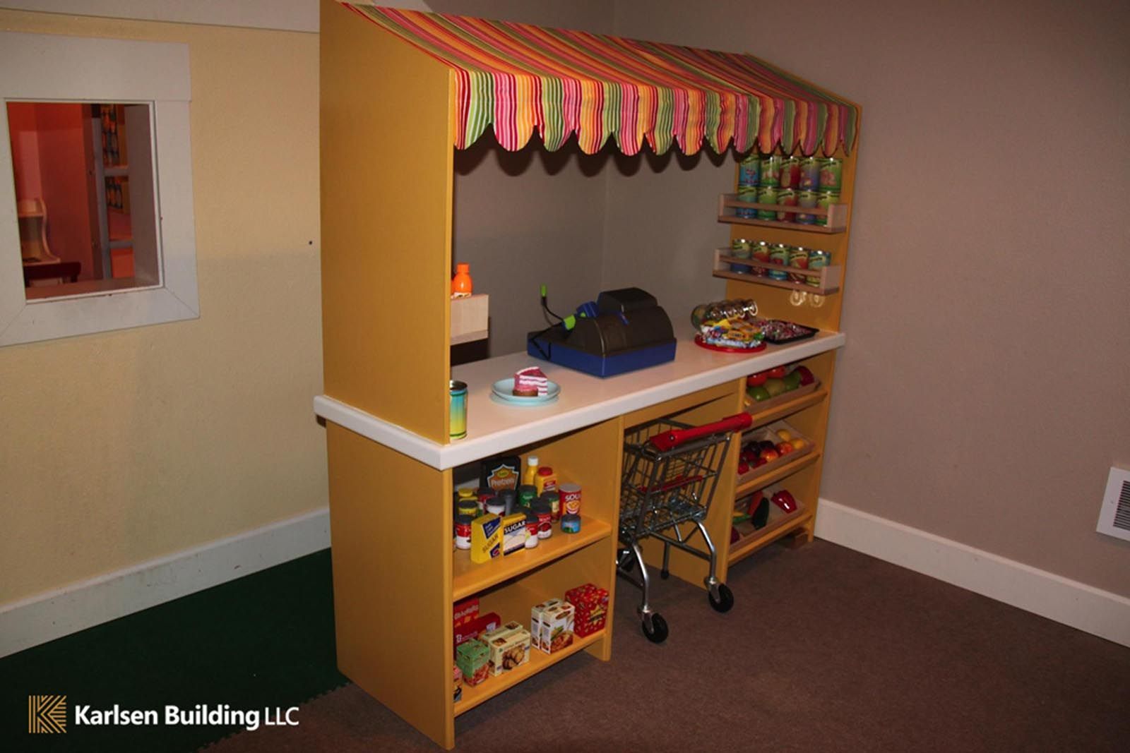 A children 's play area with a toy store and a shopping cart