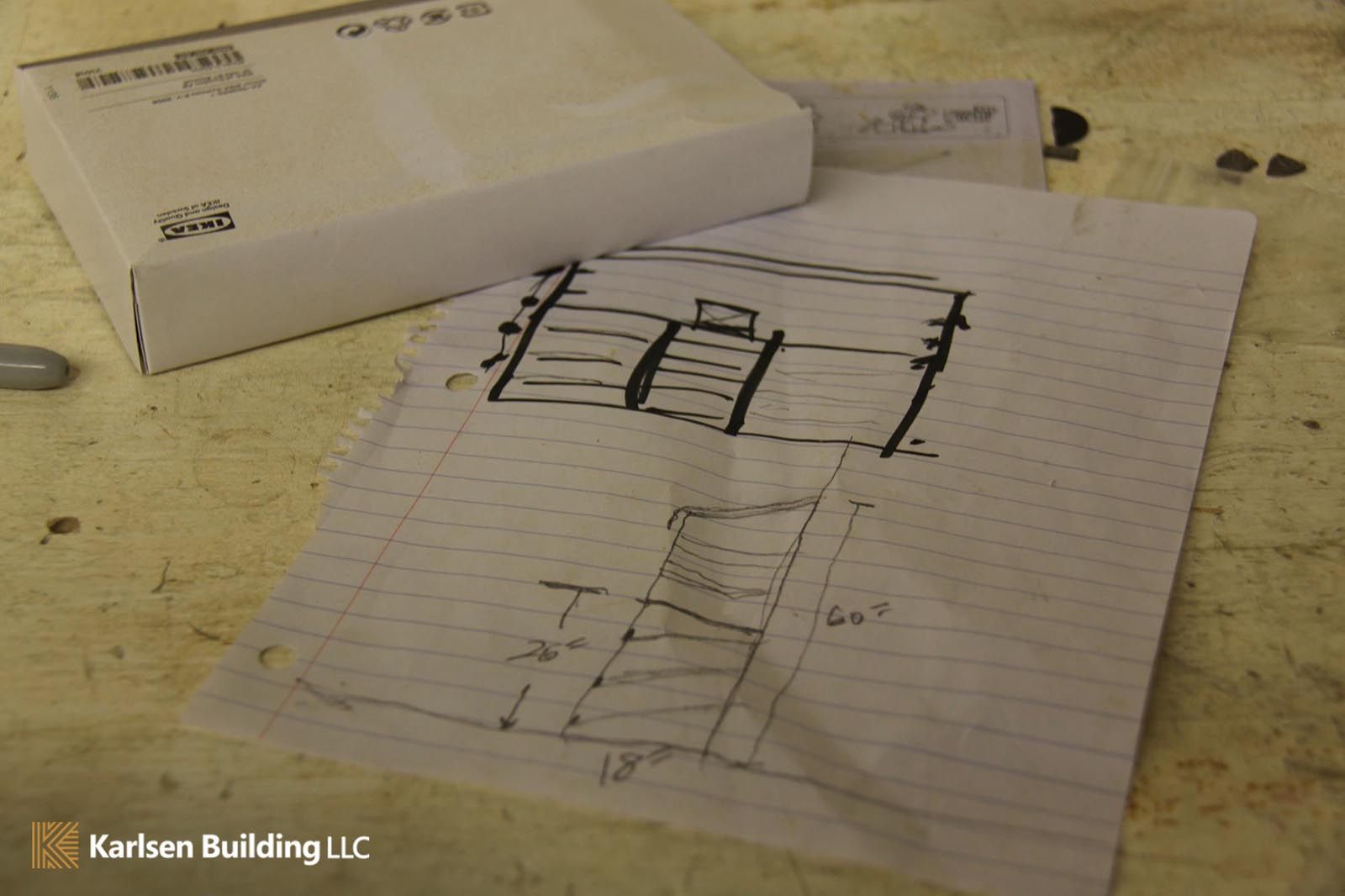 A drawing of a staircase is on a piece of paper next to a box