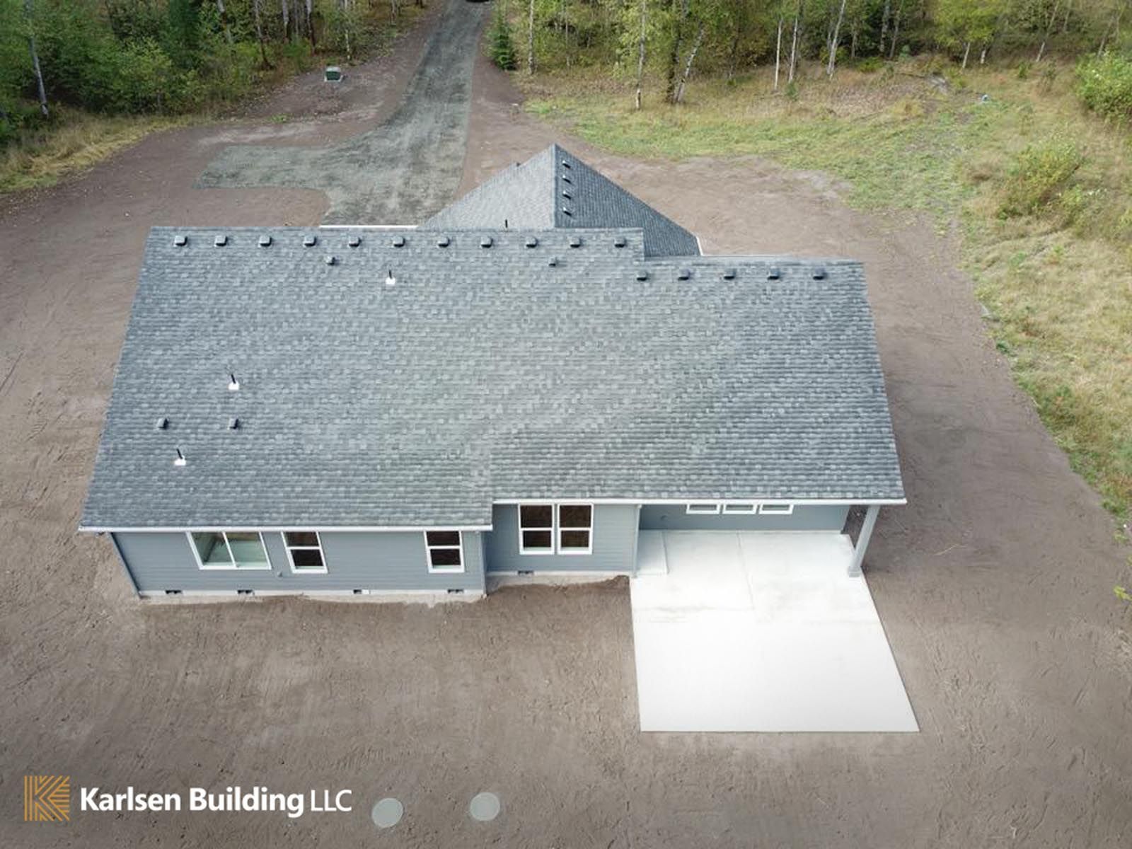 An aerial view of a house with a gray roof