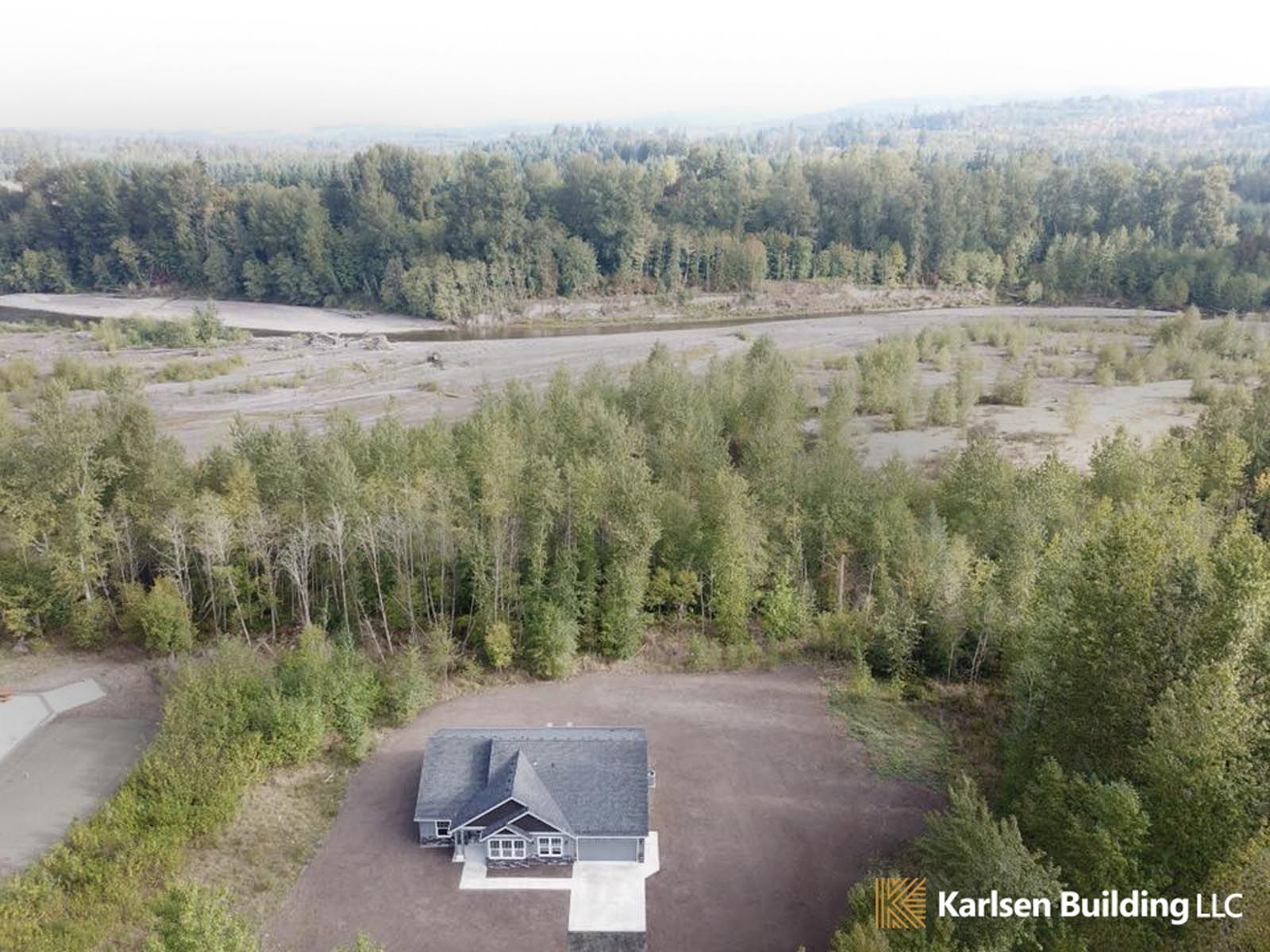 An aerial view of a house in the middle of a forest