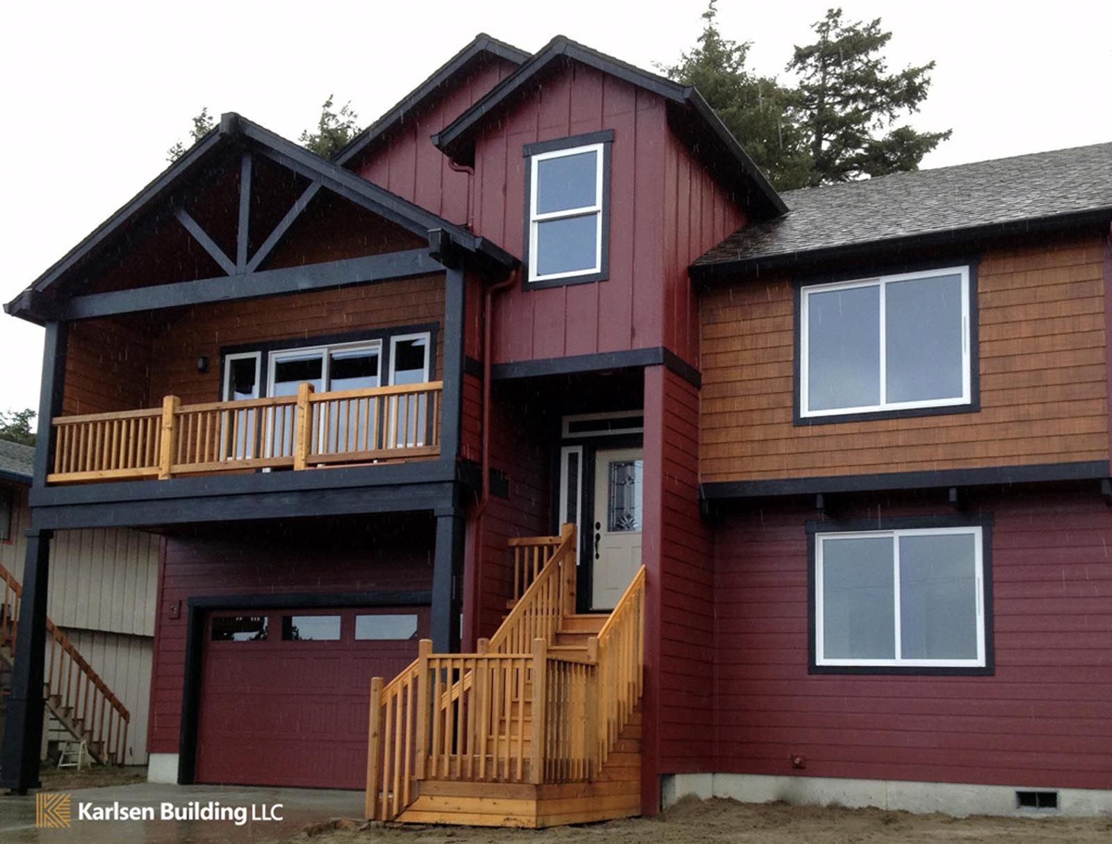 A large red house with a balcony and stairs
