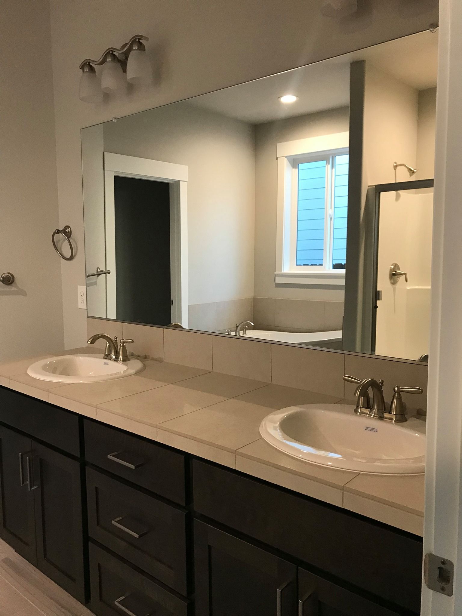 A bathroom with two sinks and a large mirror.