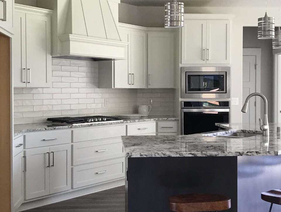 A kitchen with white cabinets and granite counter tops