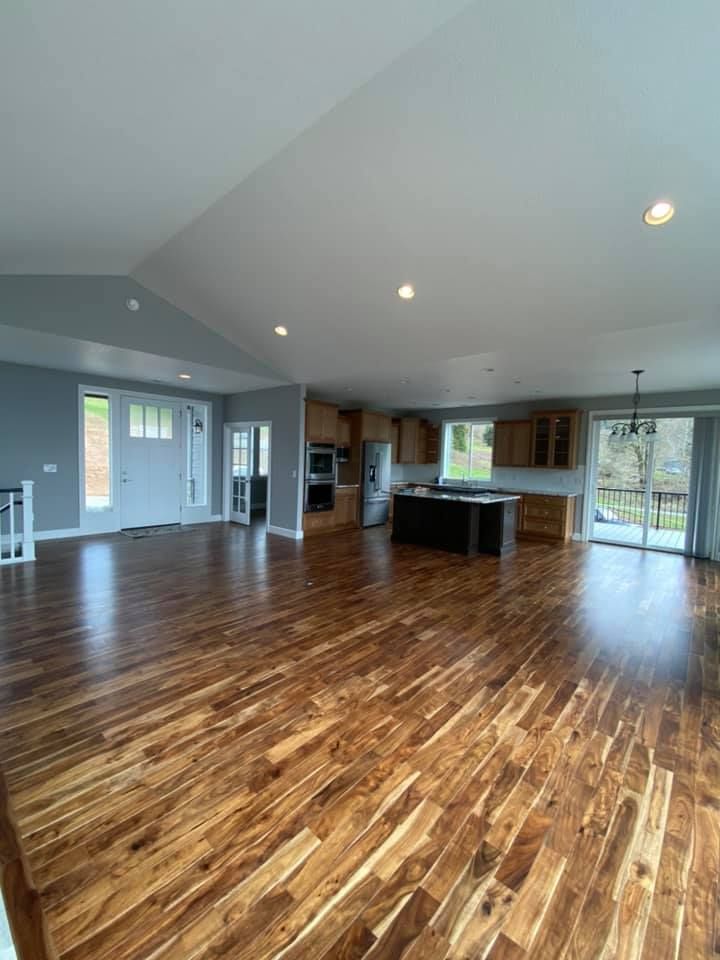 A large living room with hardwood floors and a kitchen.