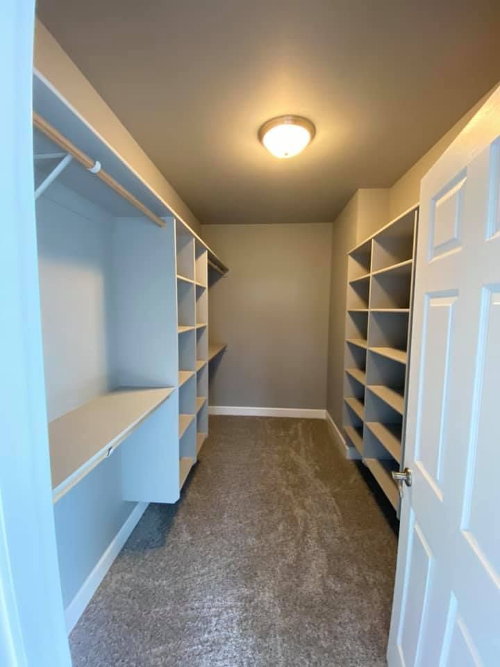 A walk in closet with lots of shelves and a door