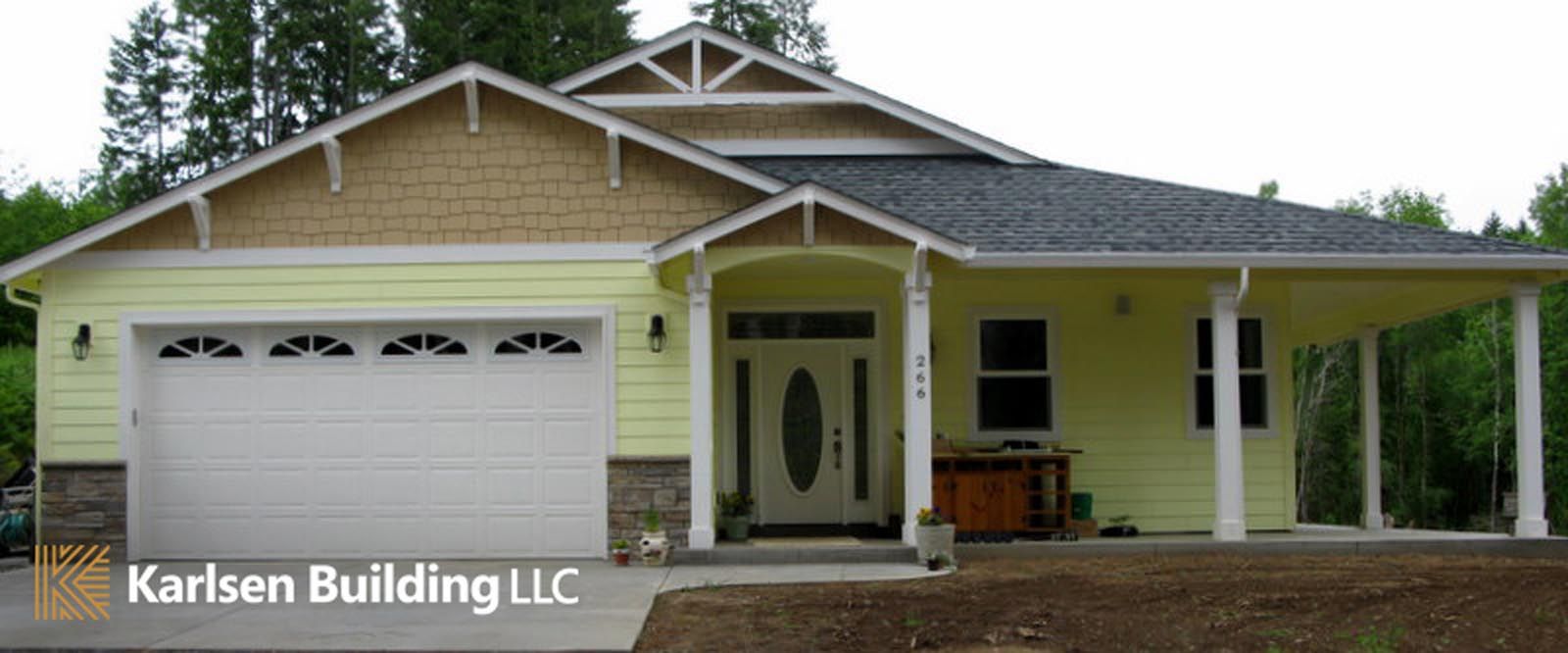 A yellow house with a white garage door is being built by karlsen building llc
