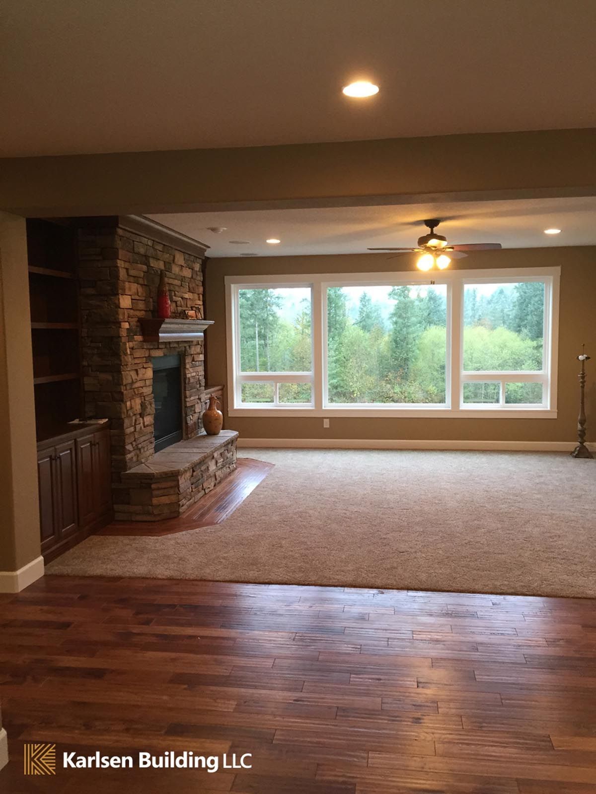 A living room with a fireplace and a lot of windows.