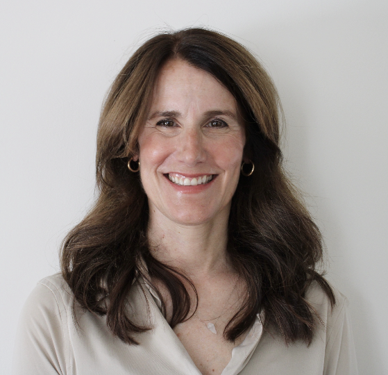 A woman with long brown hair is smiling for the camera