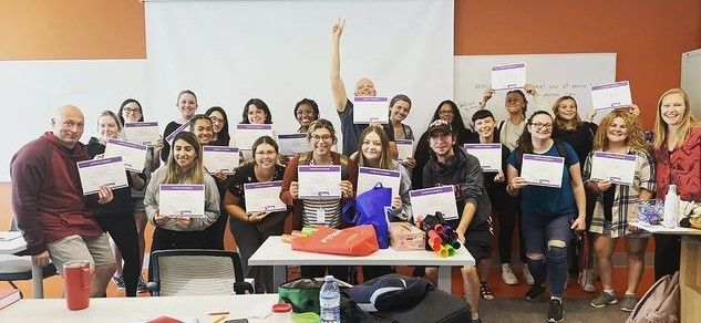 A group of people are standing around a table holding certificates.