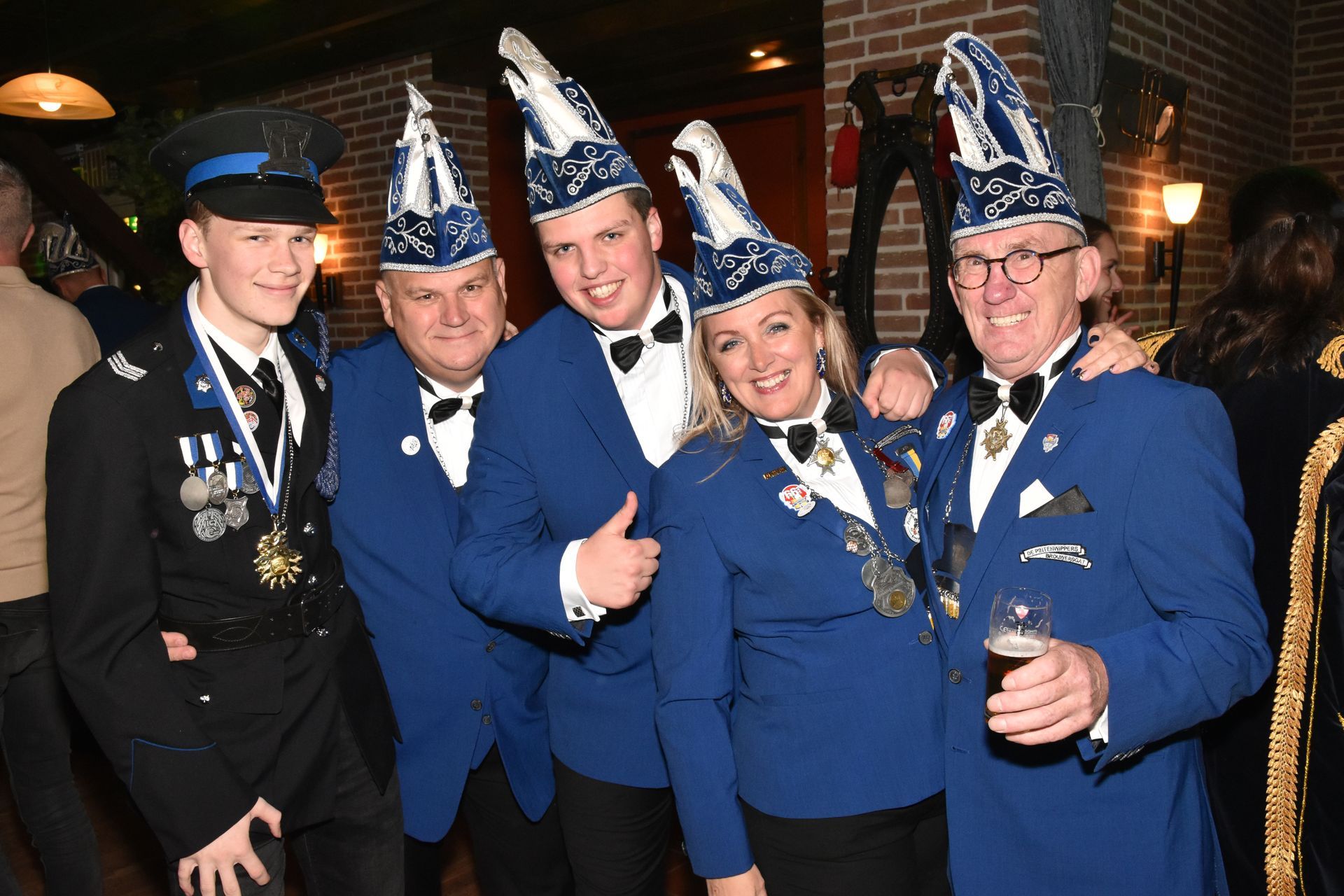 Man die lacht in een oude zwarte vrachtwagen, met pet en vest aan.