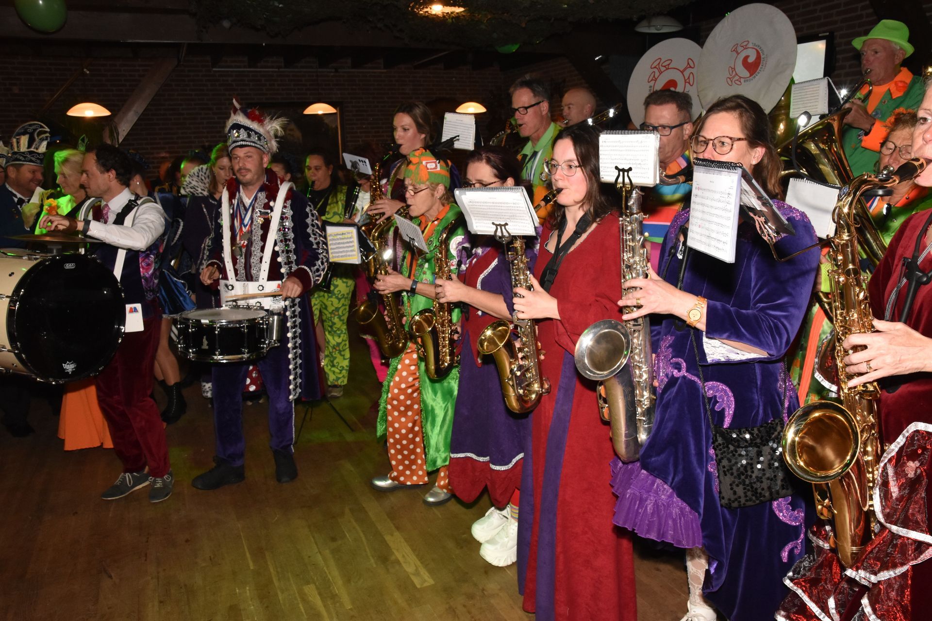 Mensen in feestelijke blauw-groene kostuums spelen binnen een tafelspel.