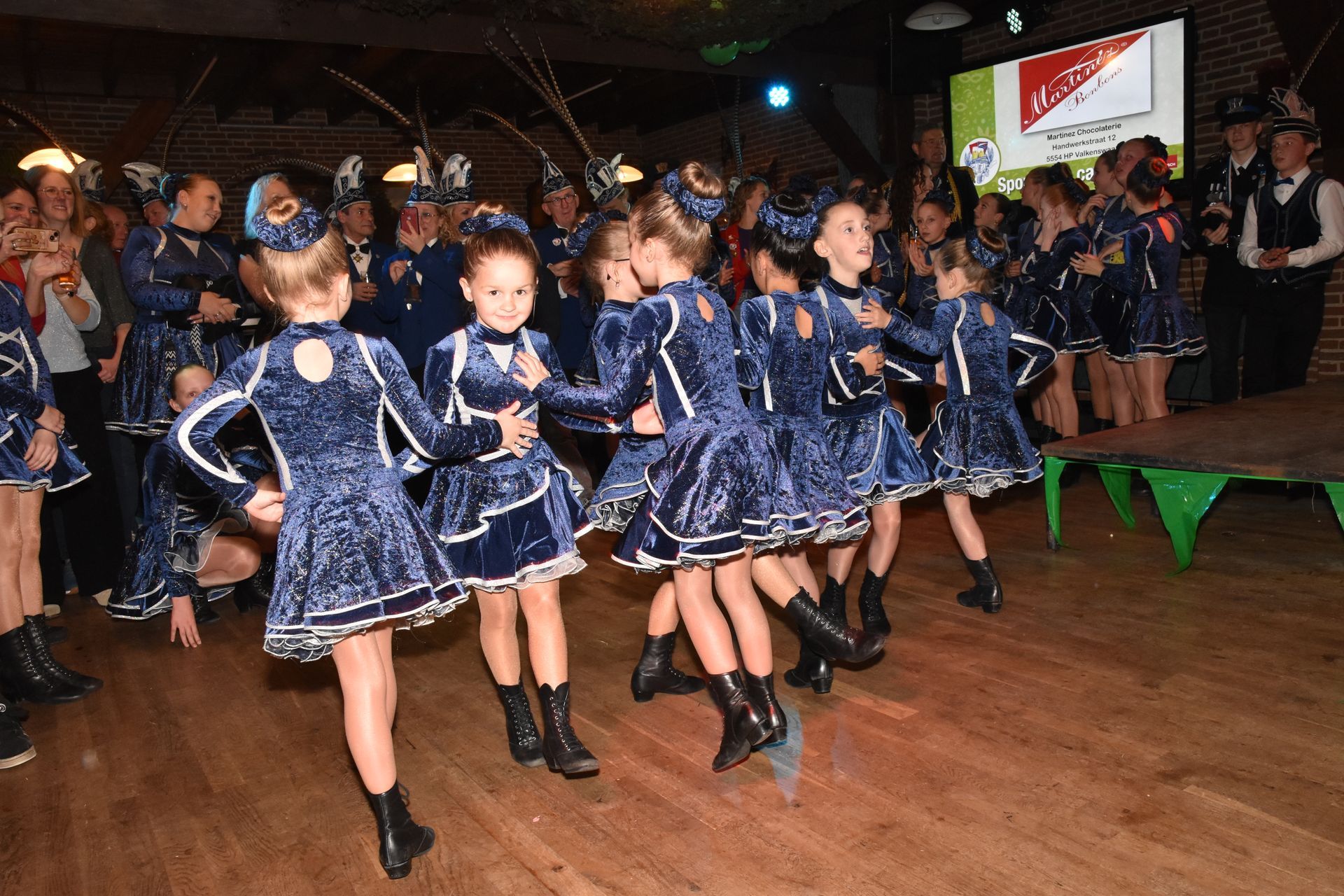 Persoon in sierlijk kostuum met snorkel die een boek leest, zittend in een kamer met ramen en gordijnen.