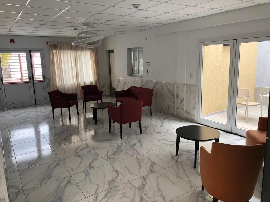 Una luminosa sala de espera con suelos de baldosas con estampado de mármol