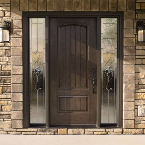 Dark brown wooden front door with sidelights, set in a brick facade. Two matching wall sconces flank the door.