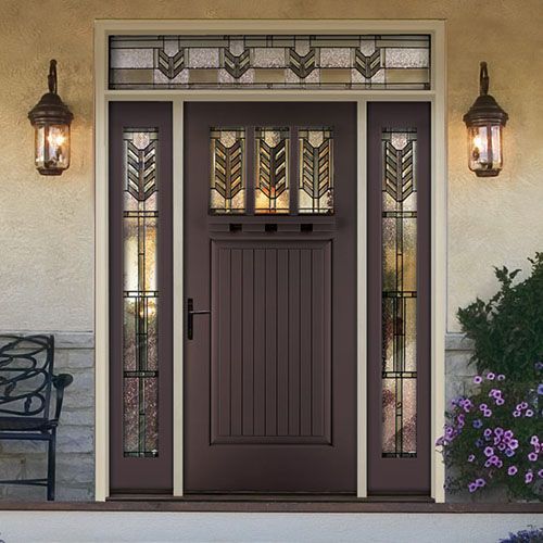 Brown Craftsman-style front door with sidelights and transom, lit by sconces, set against a stone and beige exterior.