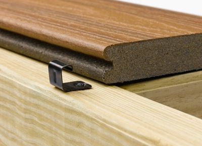 Close-up of composite deck board secured by a metal clip to a wooden joist. Brown and tan wood tones.
