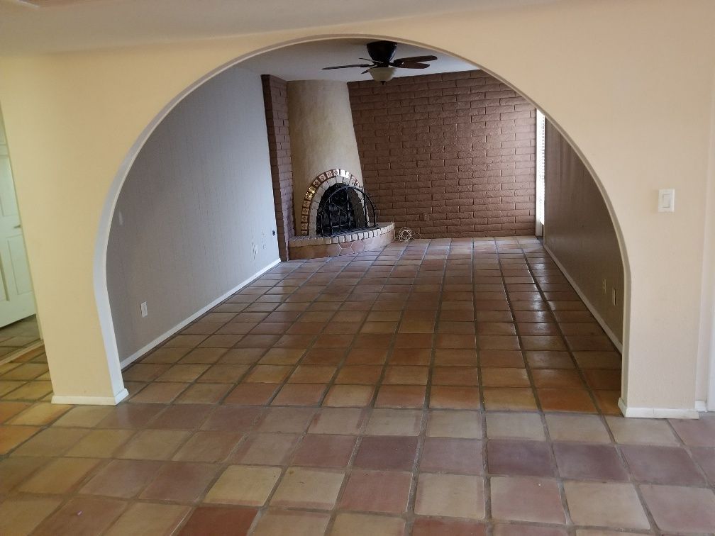 A Living Room With a Fireplace and a Ceiling Fan
