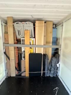 A Truck Filled With Lots of Wooden Boards and Chairs