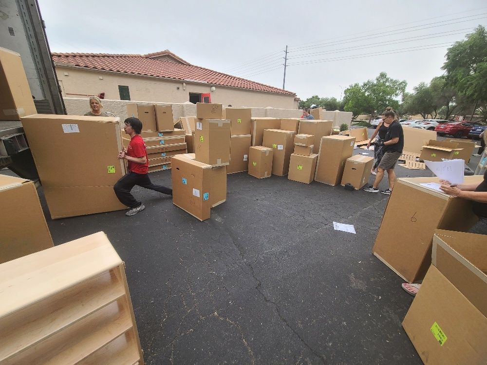 A Group of People Are Moving Boxes in a Parking Lot