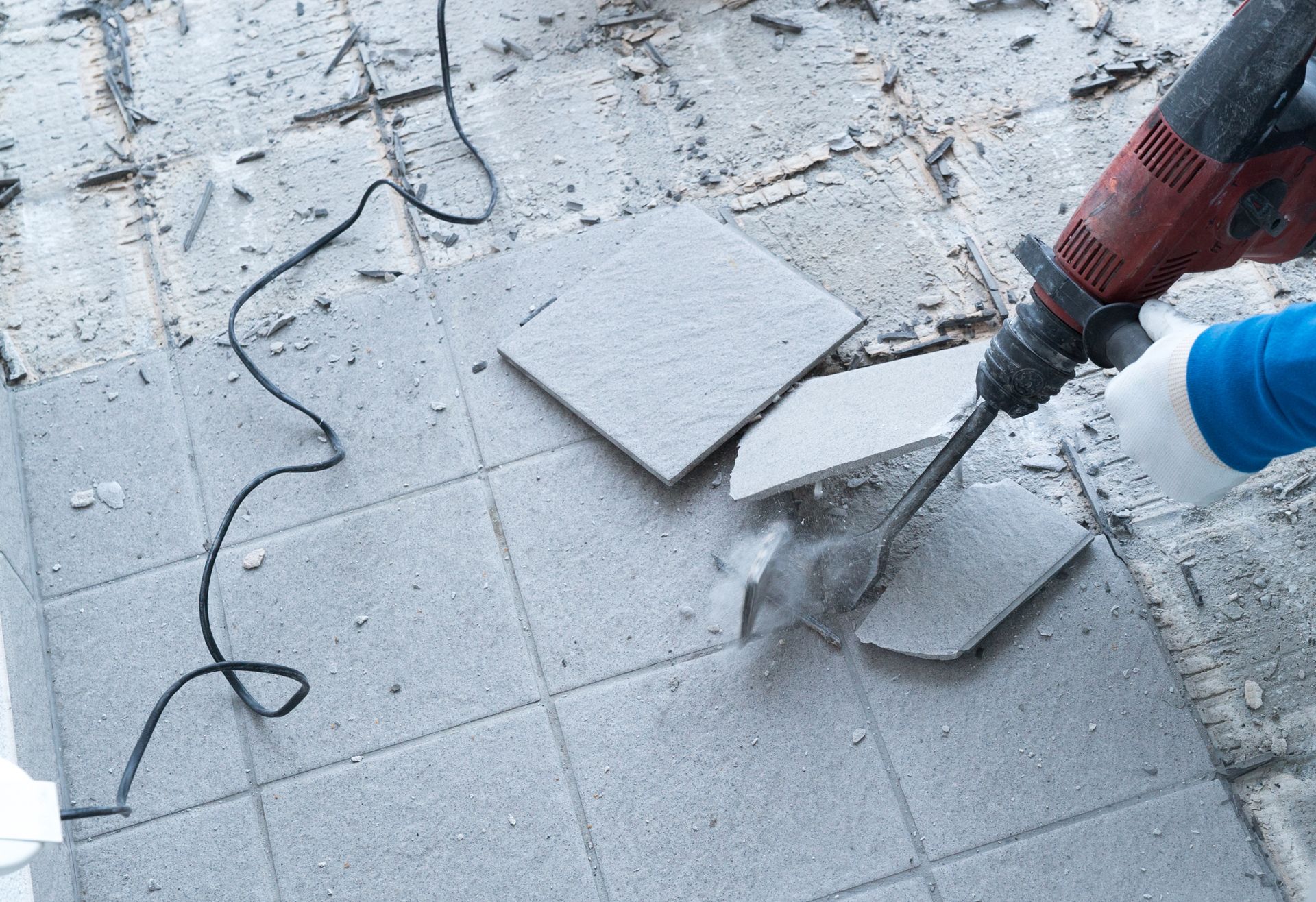 A Person is Using a Hammer to Break Tiles on the Floor