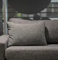 Gray sofa with textured pillows in front of a window with blinds