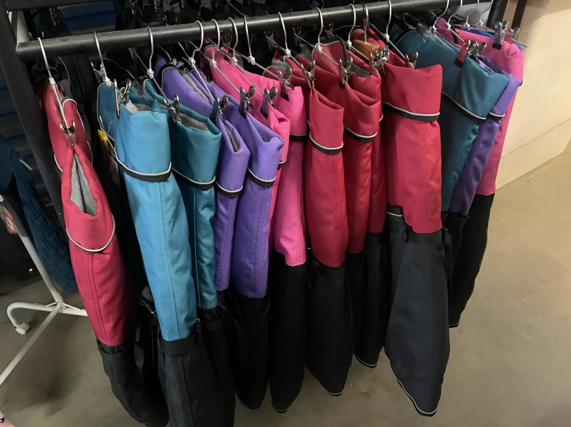 A Bunch of Jackets Are Hanging on a Rack in a Store — Perfect Pets Kingaroy Professional Dog Grooming in Kingaroy, QLD