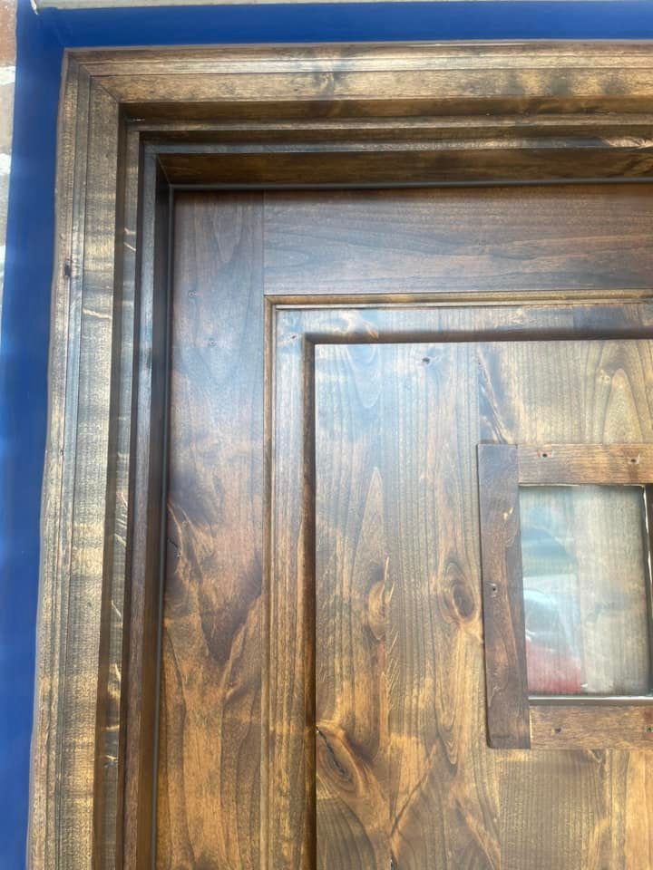 Wooden door with a stained finish and a small window.