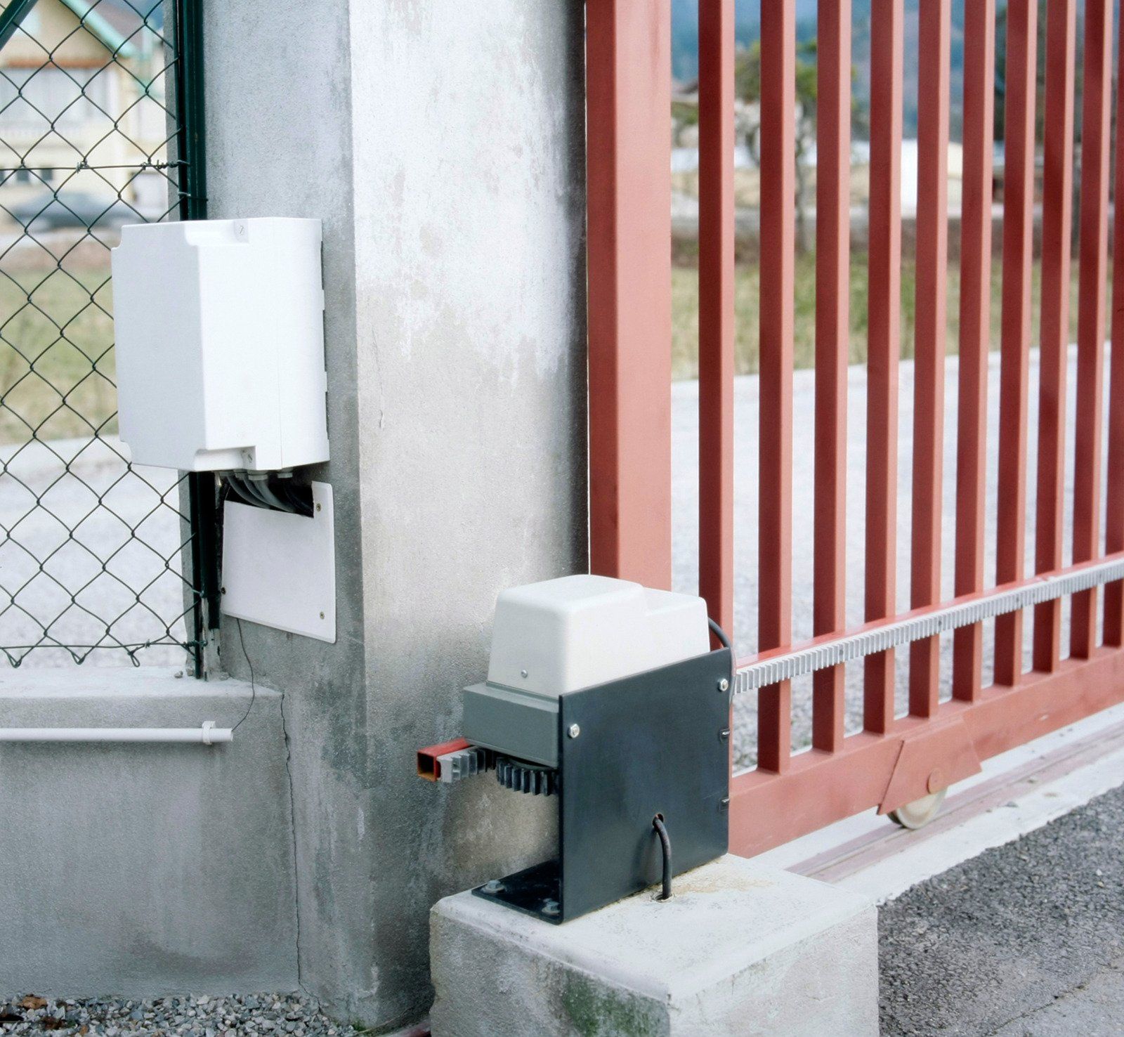 Automatic gate opener with control box and metal gate.