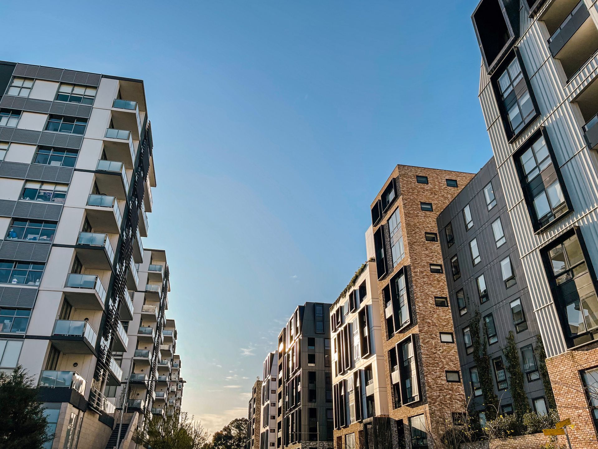 A row of apartment buildings in a city with a blue sky in the background.
